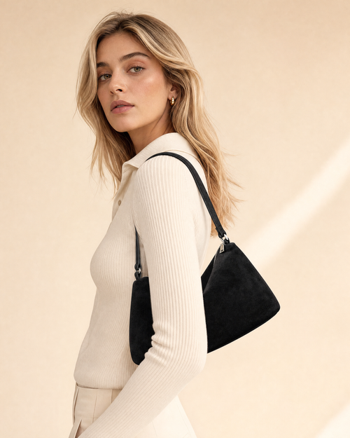Black suede shoulder bag worn on model, slim shoulder drop and compact everyday profile - Ravzelo