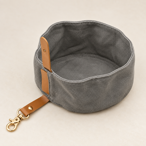 Grey soft-sided dog feeding bowl, open to show its stitched rim, attached tab, strap and clip - Ravzelo